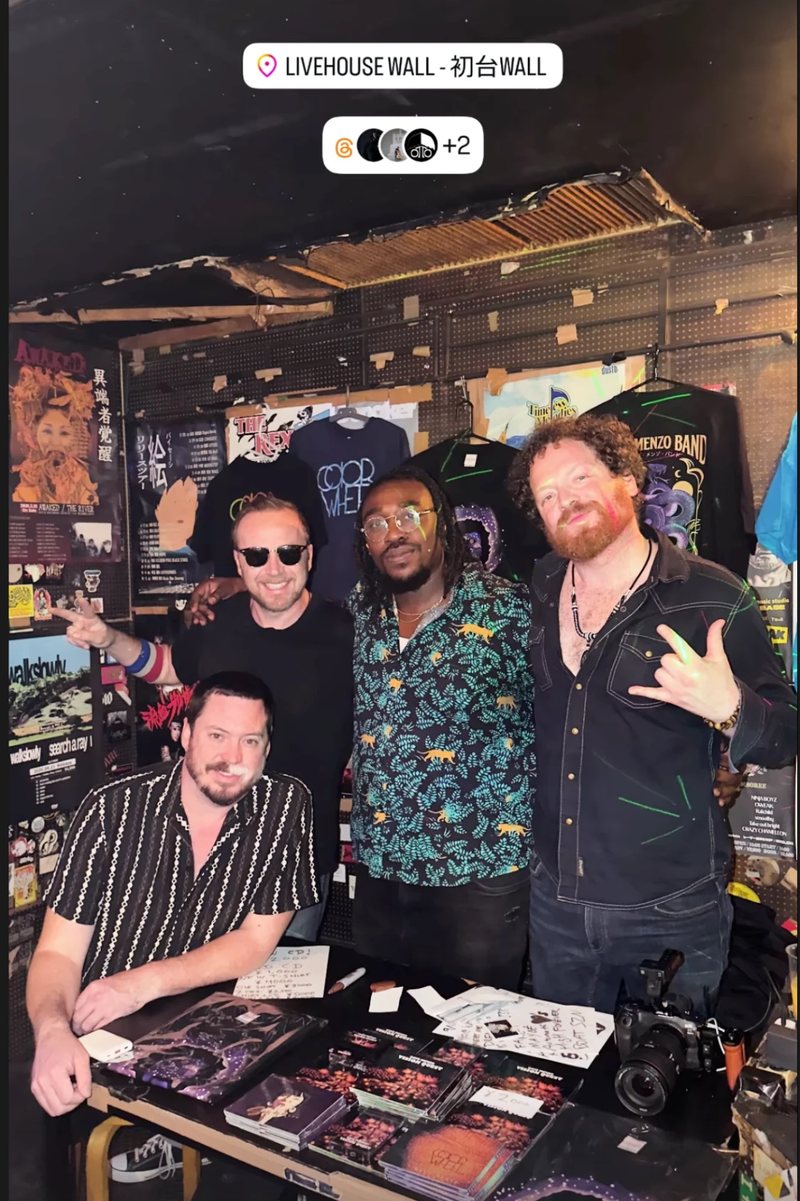 The band at the merch table at Livehouse WALL, Hatsudai, with Vision Quest CDs and tour shirts